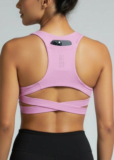 Woman wearing a pink sports bra and black shorts on a gray background. Woman wearing a white sports bra with 'STRYKE FIT' branding on a gray background. The ATHLETE CROP TOP is a new version of one of our most popular styles - Stryke Crop Top. This crop has a discreet back pocket to stash your phone, gels, or any running essentials.&nbsp;

The racerback design follows the natural line of your shoulders, unlocking full arm mobility while delivering uncompromising support. Lightweight, breathable,