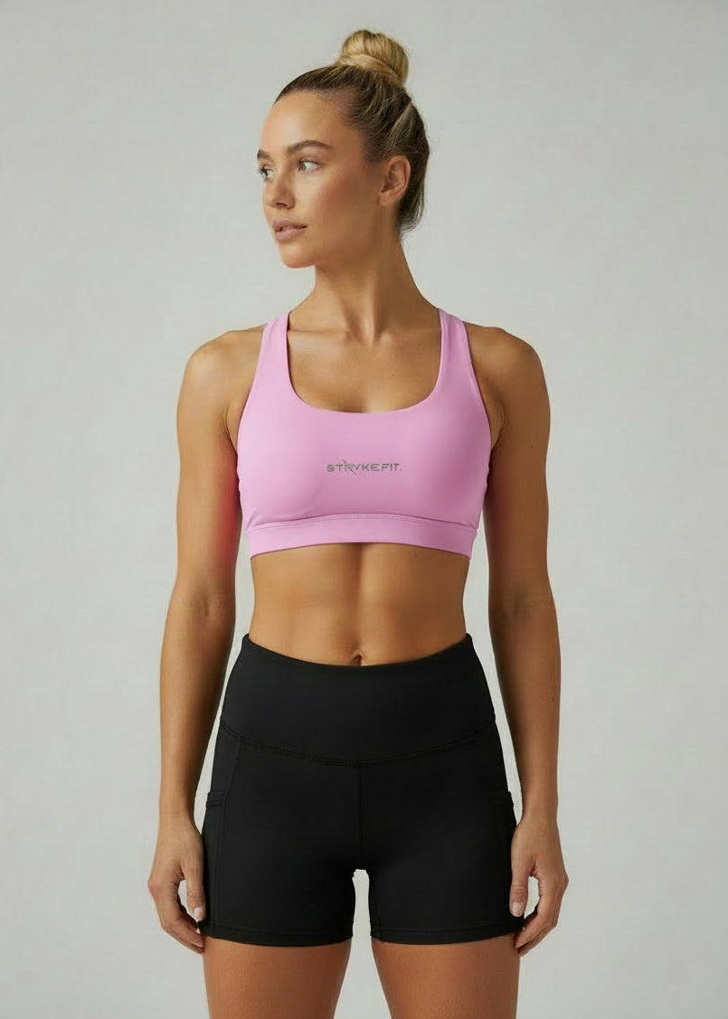 Woman wearing a pink sports bra and black shorts on a gray background. Woman wearing a white sports bra with 'STRYKE FIT' branding on a gray background. The ATHLETE CROP TOP is a new version of one of our most popular styles - Stryke Crop Top. This crop has a discreet back pocket to stash your phone, gels, or any running essentials.&nbsp;

The racerback design follows the natural line of your shoulders, unlocking full arm mobility while delivering uncompromising support. Lightweight, breathable,
