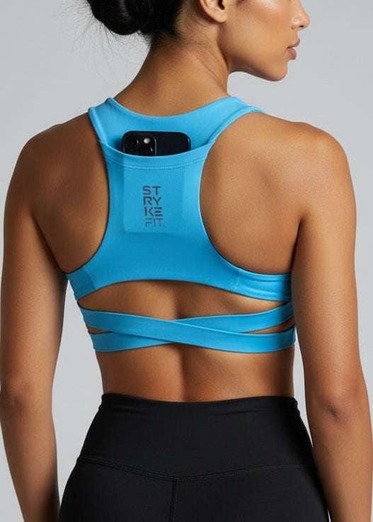 Woman wearing a blue sports bra and black shorts on a gray background. Woman wearing a white sports bra with 'STRYKE FIT' branding on a gray background. The ATHLETE CROP TOP is a new version of one of our most popular styles - Stryke Crop Top. This crop has a discreet back pocket to stash your phone, gels, or any running essentials.&nbsp;

The racerback design follows the natural line of your shoulders, unlocking full arm mobility while delivering uncompromising support. Lightweight, breathable, and made to