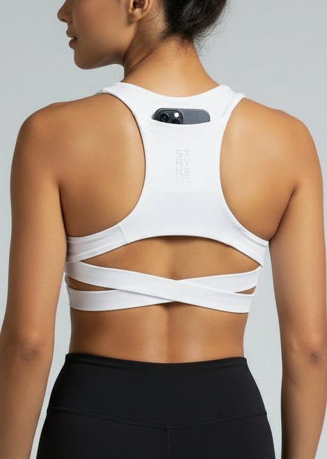 Woman wearing a white sports bra with 'STRYKE FIT' branding on a gray background. The ATHLETE CROP TOP is a new version of one of our most popular styles - Stryke Crop Top. This crop has a discreet back pocket to stash your phone, gels, or any running essentials.&nbsp;

The racerback design follows the natural line of your shoulders, unlocking full arm mobility while delivering uncompromising support. Lightweight, breathable, and made to move with you from the first step to the final sprint.