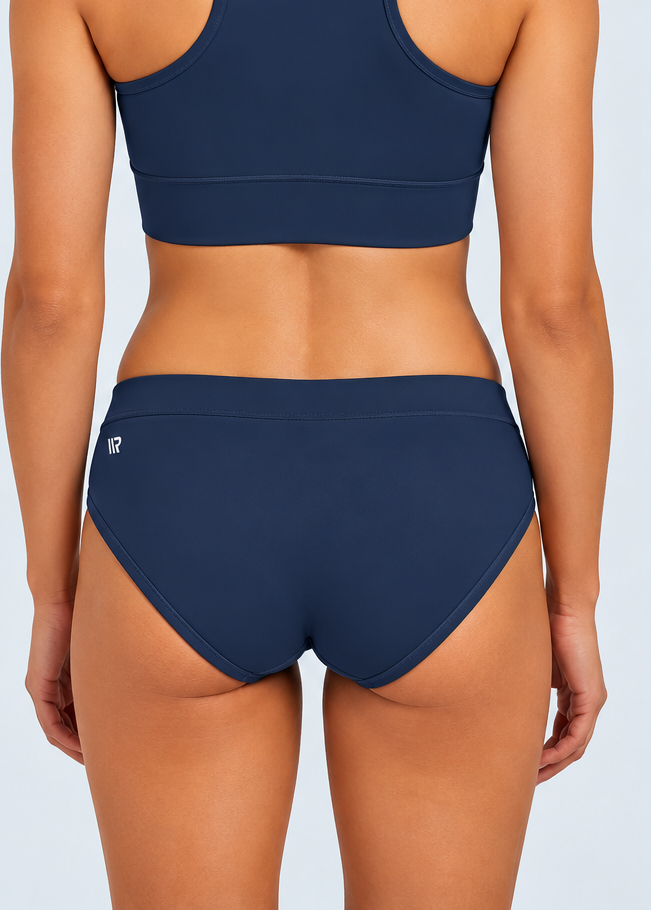 The ENERGY RUNNING BRIEFS are for athletes that want to take their performance to the next level. Engineered for speed and built for peak performance, these briefs will give you the ultimate edge on race day.A woman modeling racing briefs in a purple and dark purple striped pattern with gold 'STRYKEFIT' branding.