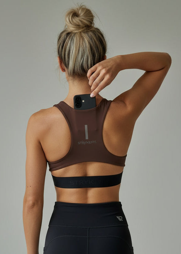 Person wearing a brown sports bra and black leggings on a plain background.
The FIT 2.0 CROP TOP is a new version of our most popular style, this crop has a discreet back pocket to stash your phone, gels, or any running essentials.&nbsp;

The racerback design follows the natural line of your shoulders, unlocking full arm mobility while delivering uncompromising support. Lightweight, breathable, and made to move with you from the first step to the final sprint.