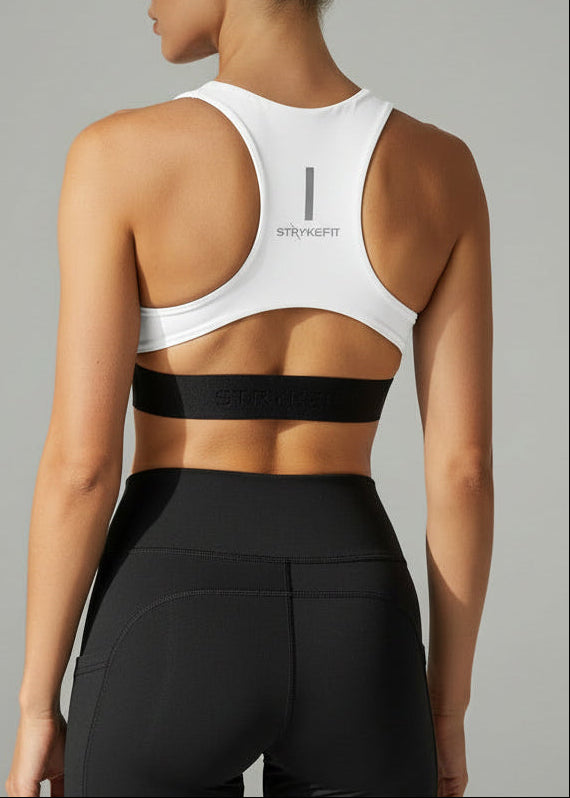 Woman wearing a white sports bra and black shorts on a gray background. The FIT 2.0 CROP TOP is a new version of our most popular style, this crop has a discreet back pocket to stash your phone, gels, or any running essentials.&nbsp;

The racerback design follows the natural line of your shoulders, unlocking full arm mobility while delivering uncompromising support. Lightweight, breathable, and made to move with you from the first step to the final sprint.