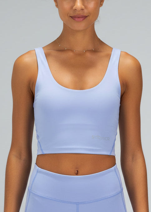 Woman wearing a light blue athletic outfit on a gray background.
The INTERVAL CROP TOP is a longer-length crop top with a built-in bra for extra support and added coverage. Designed for high-impact training this top is a great addition to any wardrobe.