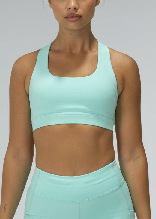 Woman wearing a matching mint green sports bra and shorts set on a gray background. The SF Elite Crop Top is designed for runners who value freedom, comfort, and effortless performance.

Cross-over back straps follow the natural curve of your shoulder blades, allowing unrestricted arm movement and a natural feel through every stride. Lightweight and streamlined, this crop moves with you from warm-up to final sprint — so you can stay focused on the run.