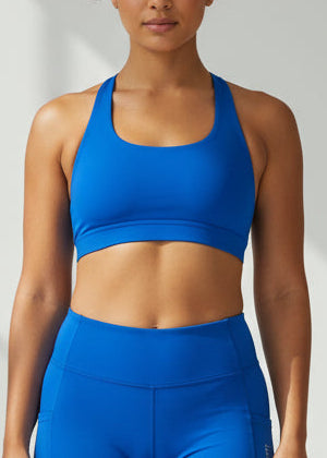 Woman wearing a blue sports bra and shorts on a white background. The SF Elite Crop Top is designed for runners who value freedom, comfort, and effortless performance.

Cross-over back straps follow the natural curve of your shoulder blades, allowing unrestricted arm movement and a natural feel through every stride. Lightweight and streamlined, this crop moves with you from warm-up to final sprint — so you can stay focused on the run.