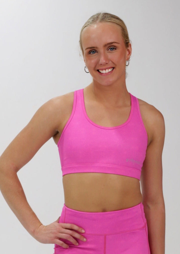 The STRYKE CROP TOP is designed with a back phone pocket enabling you to store your phone effortlessly while wearing, allowing you to listen to music, podcasts, or even just having your phone with you for personal security. The racerback straps follow the curve of your shoulder blades to allow your arms to move freely while offering maximum support. this Fuchsia pink Crop top with phone pocket is a must have this season.