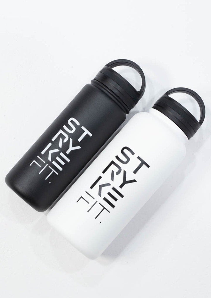 STRYKE 32OZ WATER WHITE BOTTLE is the ultimate accessory for any runner or sportsperson. The stainless steel, double walled insulated bottle keeps your water cold to help you hydrate after any run. Also featured in this image is the STRYKE 18OZ WATER BLACK BOTTLE.